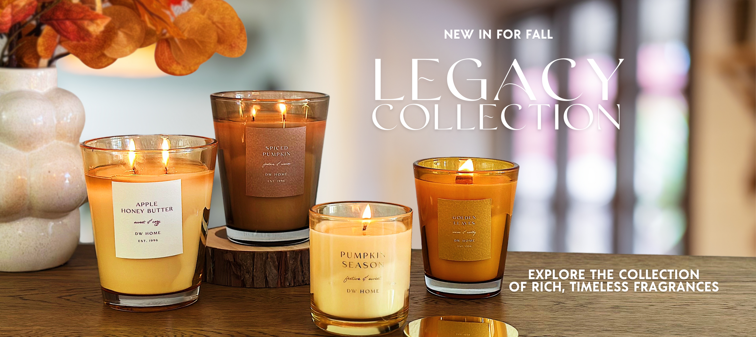 Candles from the Legacy Collection on a wooden surface with decorative elements.