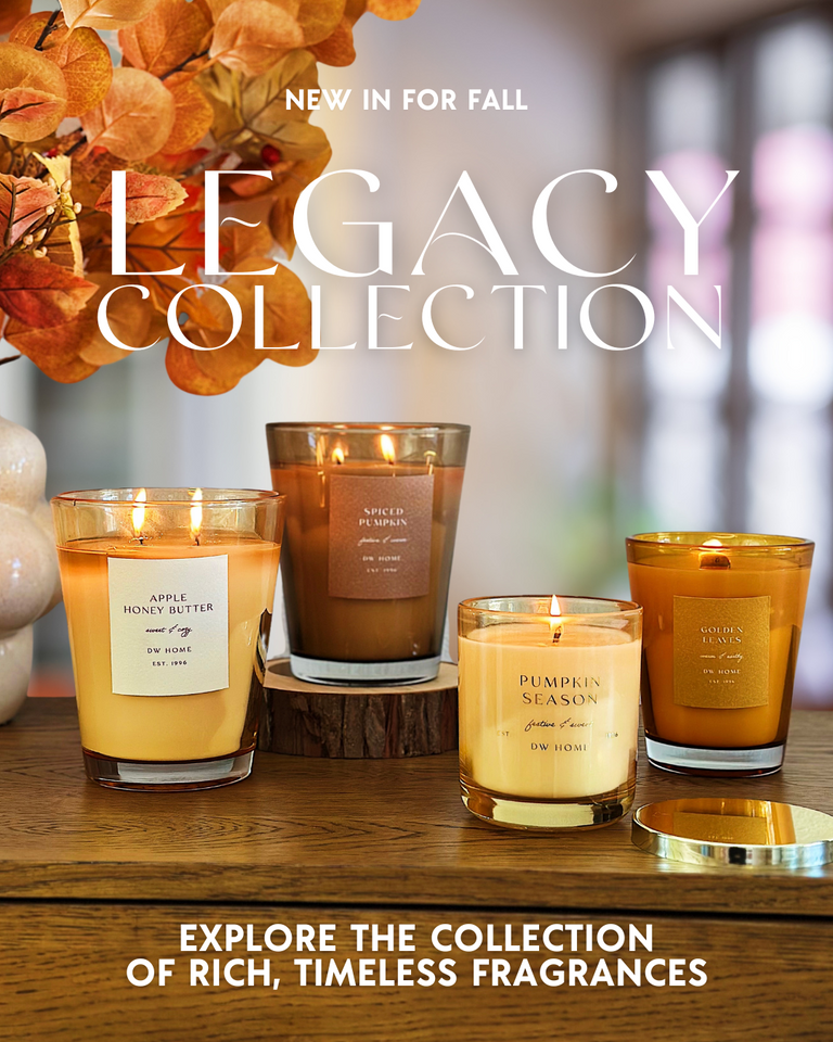 Legacy Collection candles on a wooden surface with autumn-themed decor.