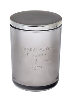 Metallic silver candle jar with 'Sandalwood & Tonka' branding on a metallic silver background