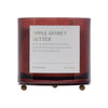 Candle with 'Apple Honey Butter' label on a white background