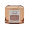 Candle labeled 'Cedar Myrrh' with a label on a white background
