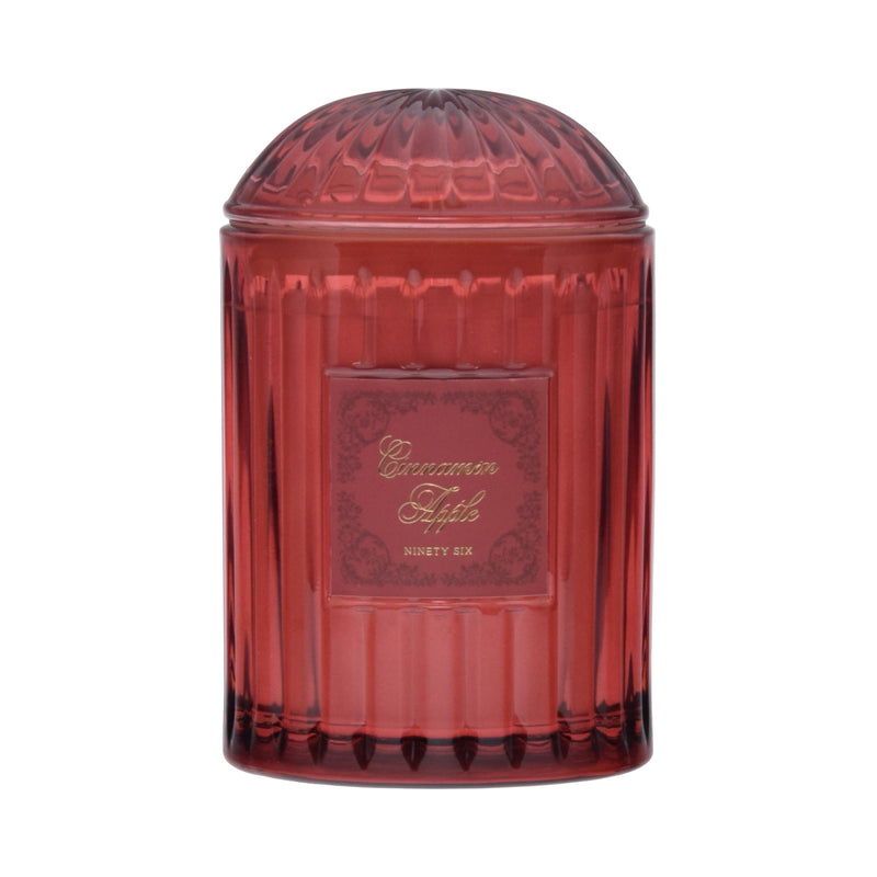 Red transparent candle jar with decorative label on a red background
