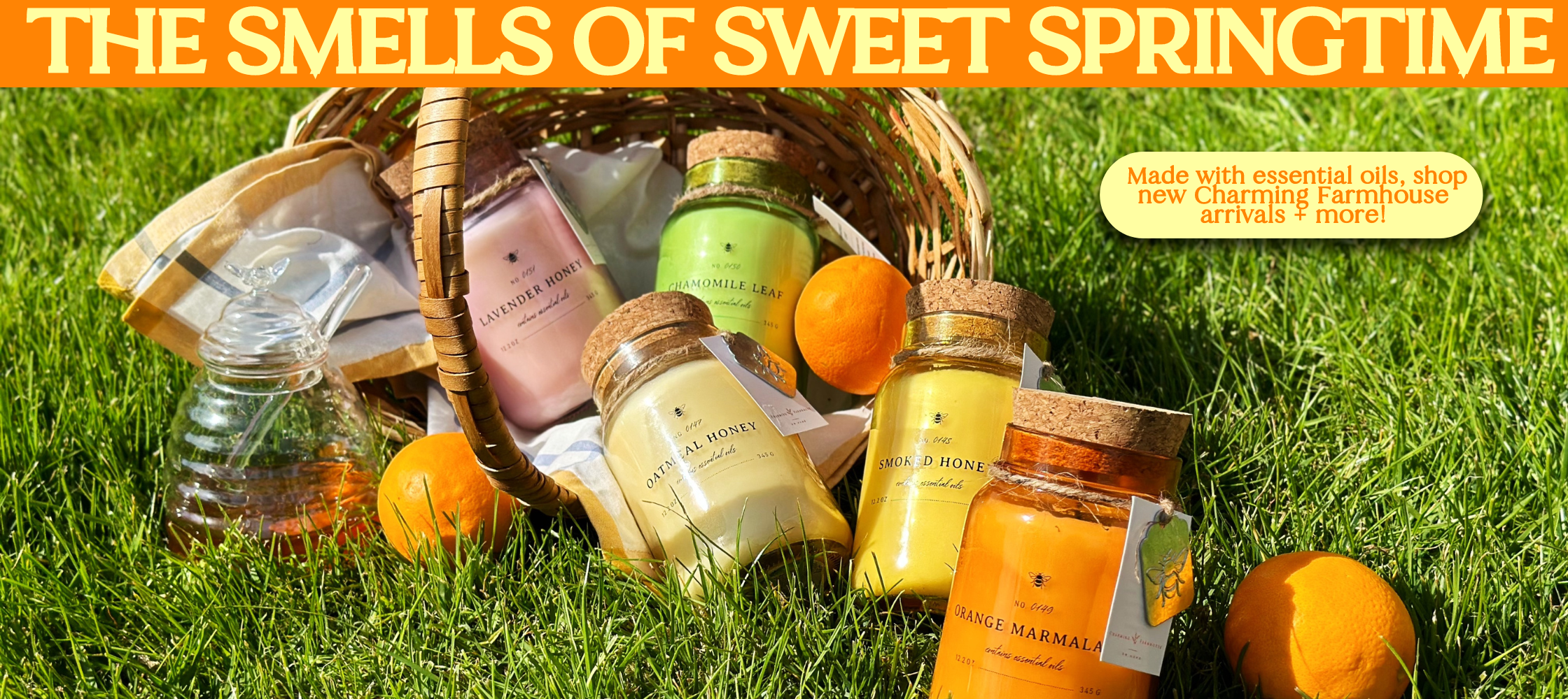 The Smells Of Sweet Springtime Banner. 5 new Charming Farmhouse candles on a grass field.
