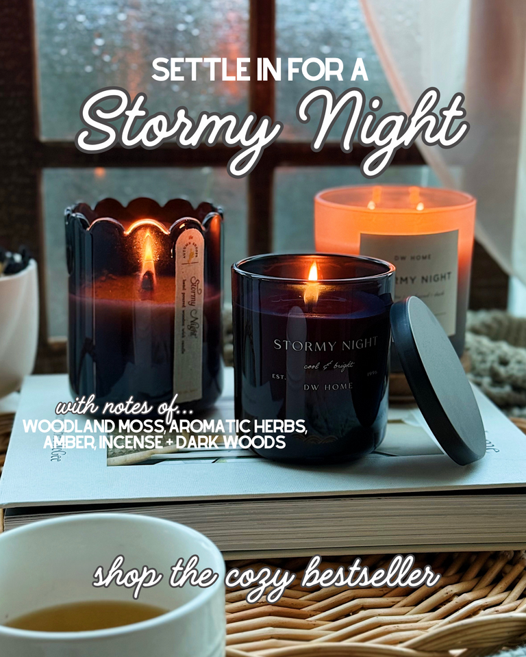 Candle with 'Stormy Night' description on a book with a cup of tea, text overlay promoting a cozy night.
