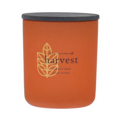 Orange candle with black lid labeled 'harvest pumpkin spice' on an orange background