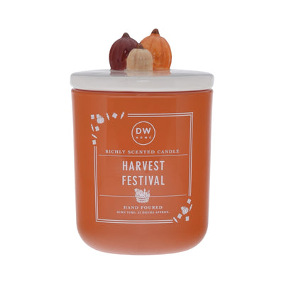 Orange candle labeled 'Harvest Festival' with decorative pumpkin lid