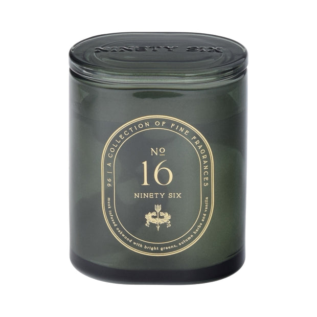 Dark green candle jar with gold text on a dark green background