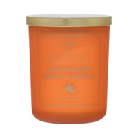 Orange candle with a gold lid on a white background