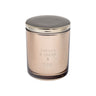 Vanilla and Toffee candle in a glass jar with a metallic lid on a metallic background