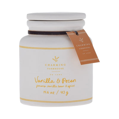 White candle jar with 'Charming Farmhouse' label and vanilla pecan scent on a white background